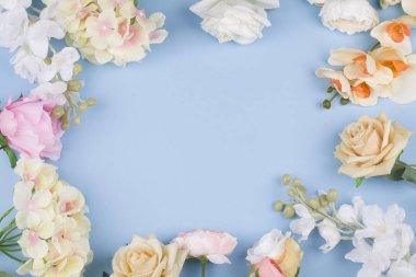 Mavi arka planda canlı renklere sahip çeşitli farklı çiçekler.