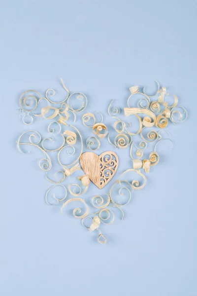 Corazón de virutas de madera con corazón de madera en el centro sobre fondo azul, concepto para el día de San Valentín — Foto de Stock