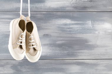 Mavi ahşap arka planda beyaz bir çift spor ayakkabı.