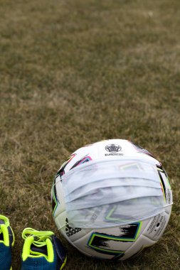 Sahada tıbbi maskeli futbol topu. Euro 2020 futbol turnuvası. Kapat.