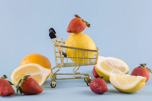 Frische Zitronen Und Erdbeeren Mit Einkaufskorb Auf Blauem Hintergrund Nahaufnahme — Stockfoto