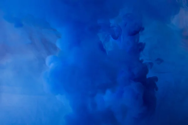 Abstract flowing liquid or blue ink in water . looks like smoke or cloud or zero gravity. splash blue paint abstract background