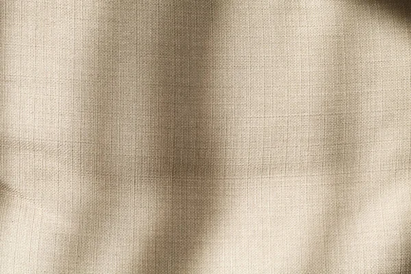 The shadow of the plant shines through the fabric. Linen fabric texture. Natural mood with shadow and light