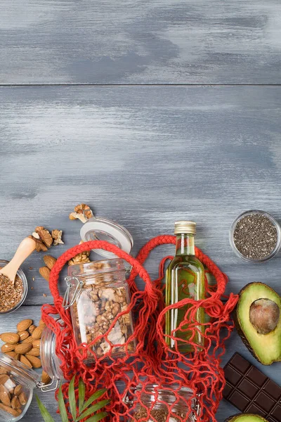 健康脂肪来源亚麻坚果油鳄梨籽和苦巧克力蓝木背景 健康食品生态概念 复制空间 — 图库照片