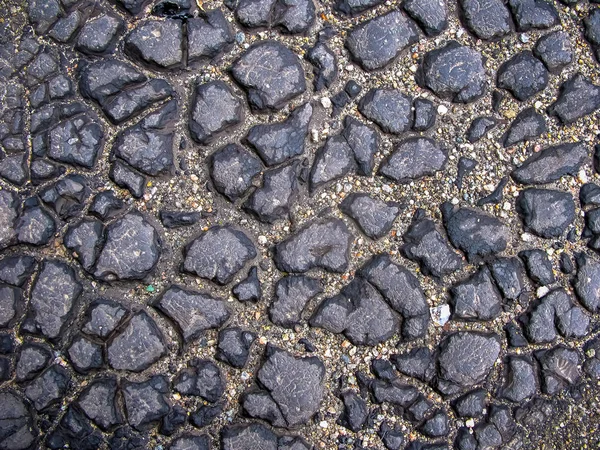 Temná asfaltová cesta s prasklinami. Textura pozadí — Stock fotografie