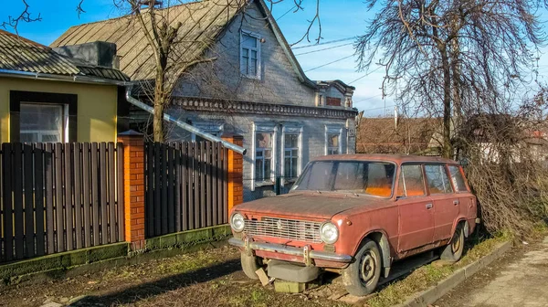 Старый автомобиль стоит на улице рядом с домом — стоковое фото