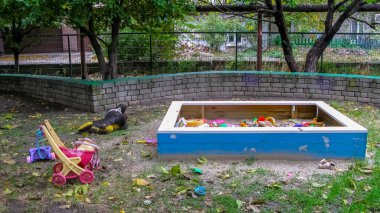 Çocukların oyun parkındaki karantina bölgesinde panik içinde bıraktıkları oyuncaklar. Virüs saldırısının sonuçları. Çocuksuz oyun alanı.