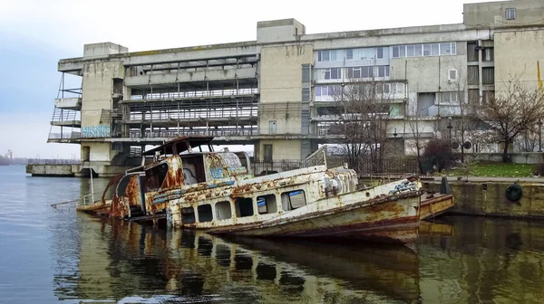 İskeledeki eski, paslı gemi. Güverteye su doldur. Ukrayna, Dnipro 27 Şubat 2020. Geri Aktar.