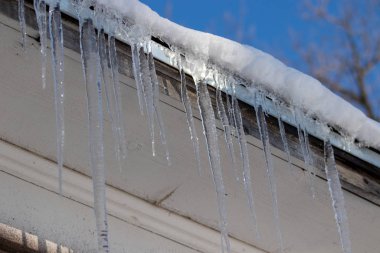 Ice Sickles hanging from roof top clipart