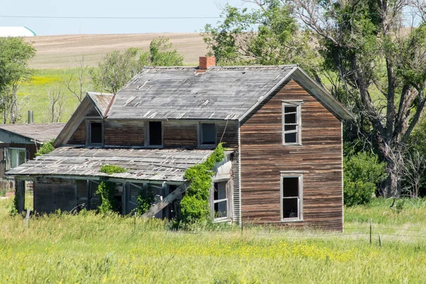 A old abandon farm house with a grass field — 图库照片