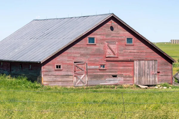 An old barn in a grassy field — 图库照片