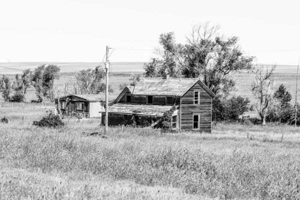 荒废的老房子，在一片白黑的田野里 — 图库照片