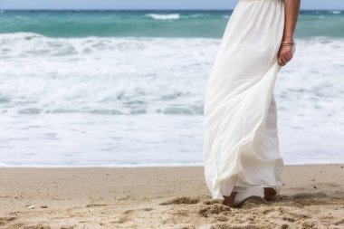 Plajda beyaz elbiseli bir kadın