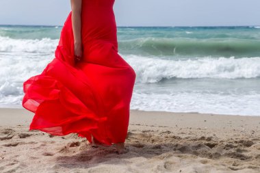 Sahilde Kırmızı elbiseli kadın