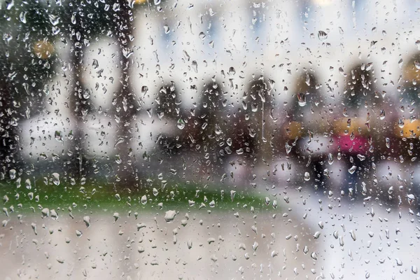 Regentropfen auf einer Fensterscheibe, verschwimmen Gebäude im Hintergrund. — Stockfoto