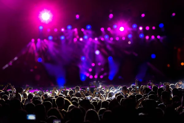 Siluetas de la multitud de conciertos frente a luces de escenario brillantes —  Fotos de Stock