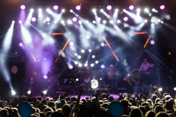 Siluetas de la multitud de conciertos frente a luces de escenario brillantes —  Fotos de Stock