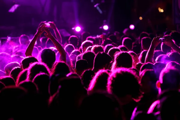 Sagome di folla concerto di fronte a luci di scena luminose — Foto Stock