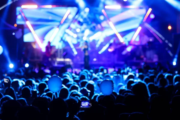 Silhuetter av konsert publiken framför ljusa scenbelysning — Stockfoto