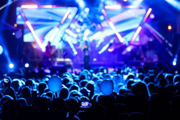 Parlak sahne ışıkları önünde konser kalabalığının siluetleri — Stok fotoğraf