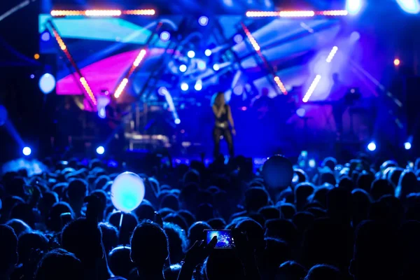 Siluetas de la multitud de conciertos frente a luces de escenario brillantes —  Fotos de Stock