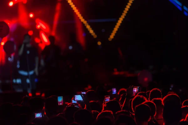 Hand met een smartphone records live muziek festiva — Stockfoto