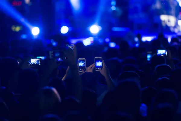 Рука со смартфоном записывает живой музыкальный фестиваль — стоковое фото