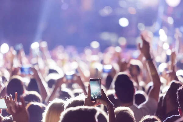Mão com um smartphone grava música ao vivo festiva — Fotografia de Stock
