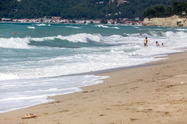 Matka pomůže její děti těšit na pláž. Chalkidiki, Řecko — Stock fotografie