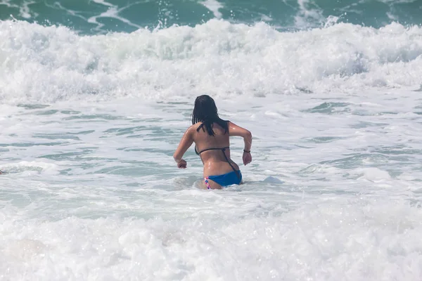 Felismerhetetlen fiatal felnőtt a tenger játék a hullámokkal — Stock Fotó