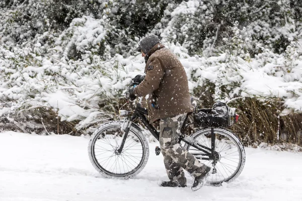 Unknown man walking with the bike on a snowy landscape in northe — Stock Photo, Image