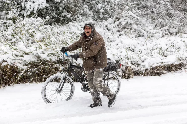 Homem desconhecido andando com a bicicleta em uma paisagem nevada em northe — Fotografia de Stock