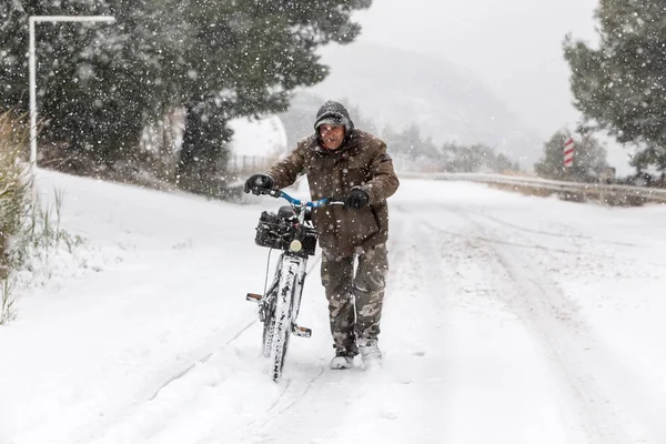 Unknown man walking with the bike on a snowy landscape in northe — Stock Photo, Image