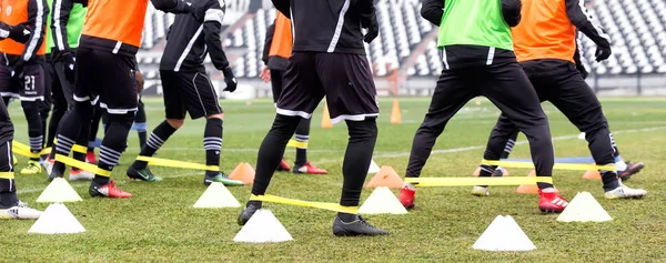 PAOK-pelaajien jalat ja jalkapalloharjoitusvälineet — kuvapankkivalokuva