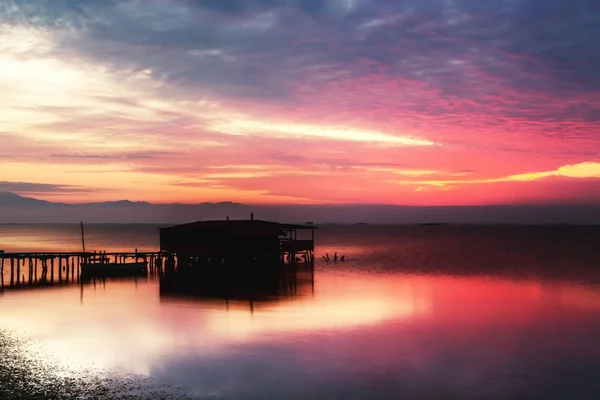 Lange blootstelling van magische zonsopgang boven de oceaan met een hut in de — Stockfoto