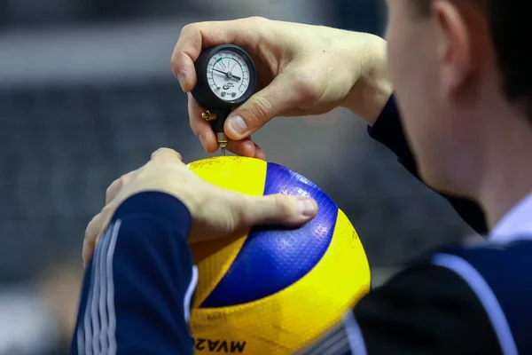 Dommeren teller lufttrykket på ballen før kampen. – stockfoto