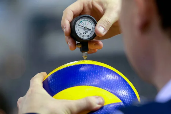 The referee counts the air pressure on the ball before the game — Stock Photo, Image