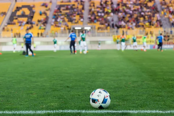 Pallone da calcio in primo piano e giocatori sfocati — Foto Stock