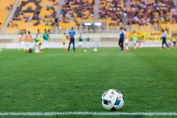 Soccer ball in the foreground and blurred players — Stock Photo, Image