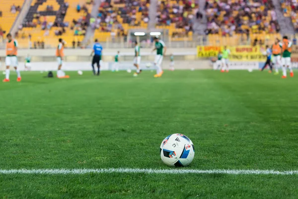 Soccer ball in the foreground and blurred players — Stock Photo, Image