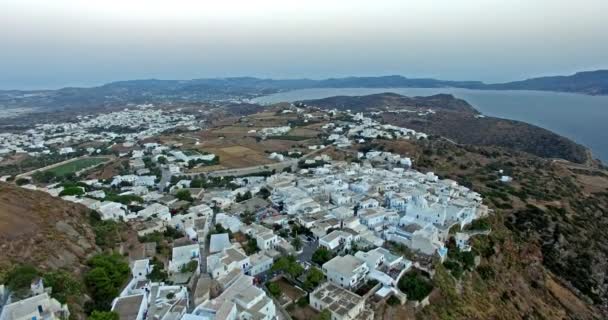 Vuelo sobre la ciudad de Plaka con hermosas casas blancas e iglesias, isla de Milos Cyclades, Grecia — Vídeo de stock