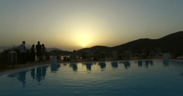 Flug über einen Pool bei Sonnenuntergang und über das Meer. ios insel, griechenland — Stockvideo