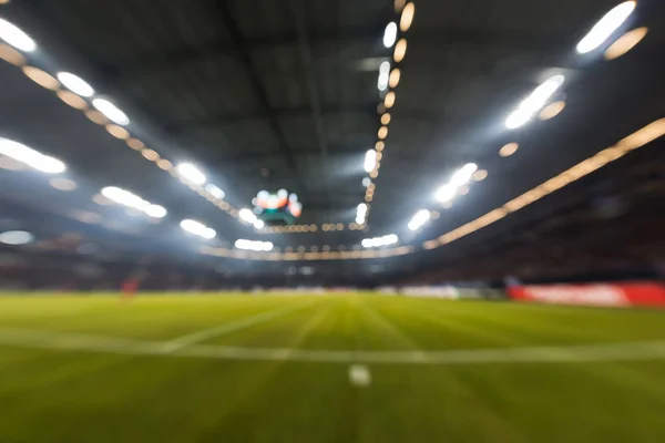 Campo desfocado com luzes e cheio de espectadores no estádio — Fotografia de Stock