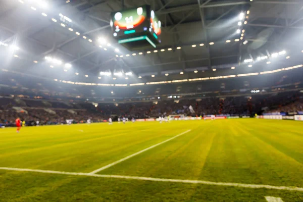 Campo desfocado com luzes e cheio de espectadores no estádio — Fotografia de Stock