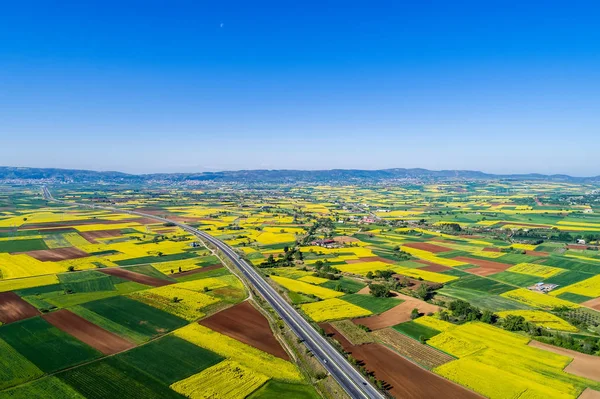 Vista aérea da estrada que passa por uma paisagem rural com flor — Fotografia de Stock