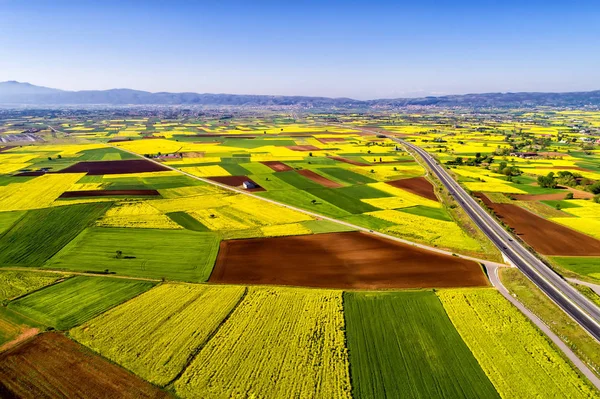 Vista aérea da estrada que passa por uma paisagem rural com flor — Fotografia de Stock
