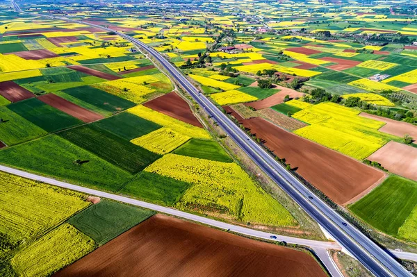 Vista aérea da estrada que passa por uma paisagem rural com flor — Fotografia de Stock