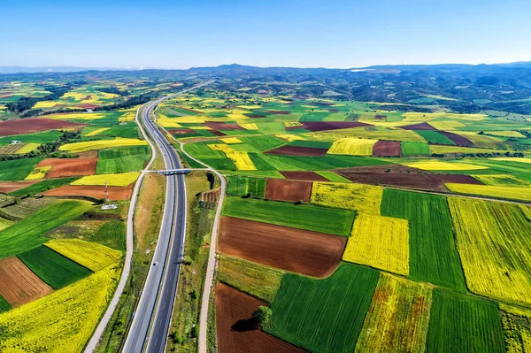 Vista aérea da estrada que passa por uma paisagem rural com flor — Fotografia de Stock