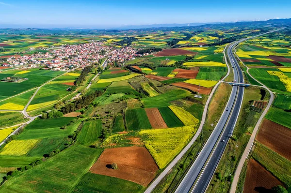 Вид з повітря на дорогу, що проходить через сільський пейзаж з цвітінням — стокове фото