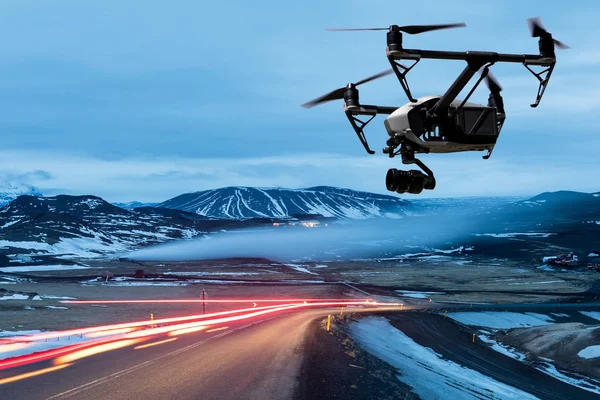 Drone quad copter with a camera flies over a road with car light — Stock Photo, Image